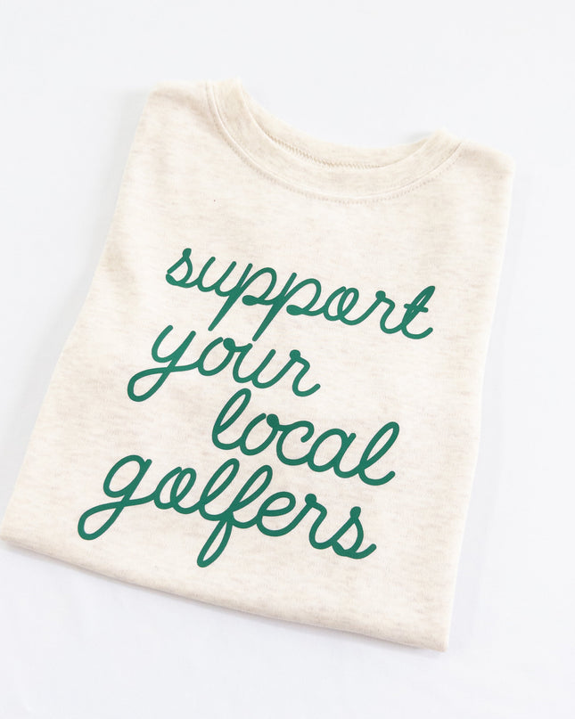 Buff Bo Outfitters' 'Support Your Local Golfers' kids' t-shirt in soft cream. A stylish and comfortable tee celebrating young golfers and the love of the game.