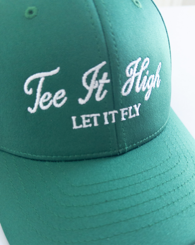 Green golf hat with white embroidered text reading 'Tee It High, Let It Fly,' classic and motivational golf headwear designed for young golfers and golf lovers, displayed on a neutral background.