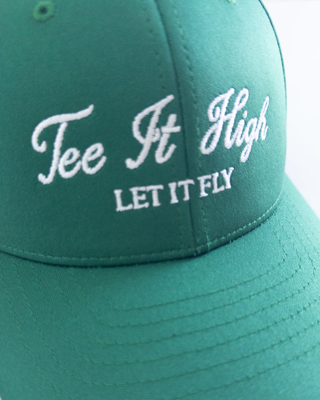 Green golf hat with white embroidered text reading 'Tee It High, Let It Fly,' classic and motivational golf headwear designed for young golfers and golf lovers, displayed on a neutral background.