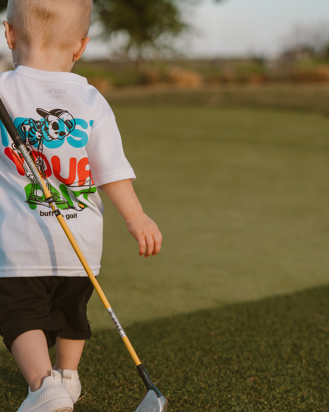 Child holding a golf club on a golf course