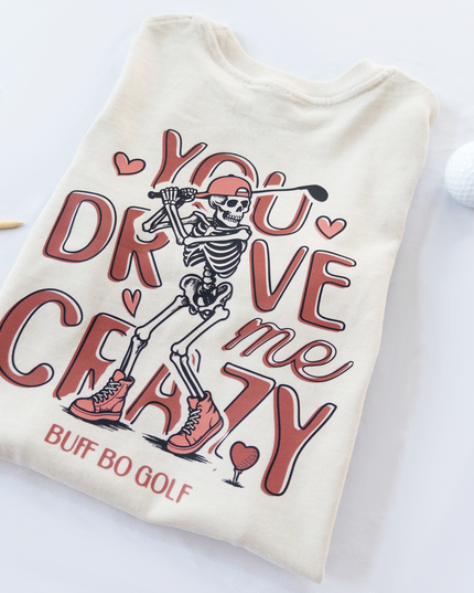 Beige t-shirt with skeleton graphic and text on a white background