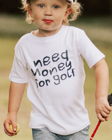 Child holding a golf club in a grassy outdoor setting
