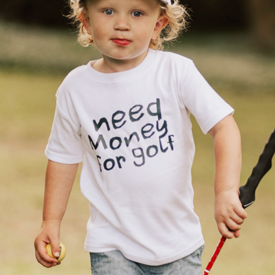 Child holding a golf club in a grassy outdoor setting